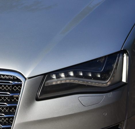 The headlight of the car is close-up. Fragment of the car body